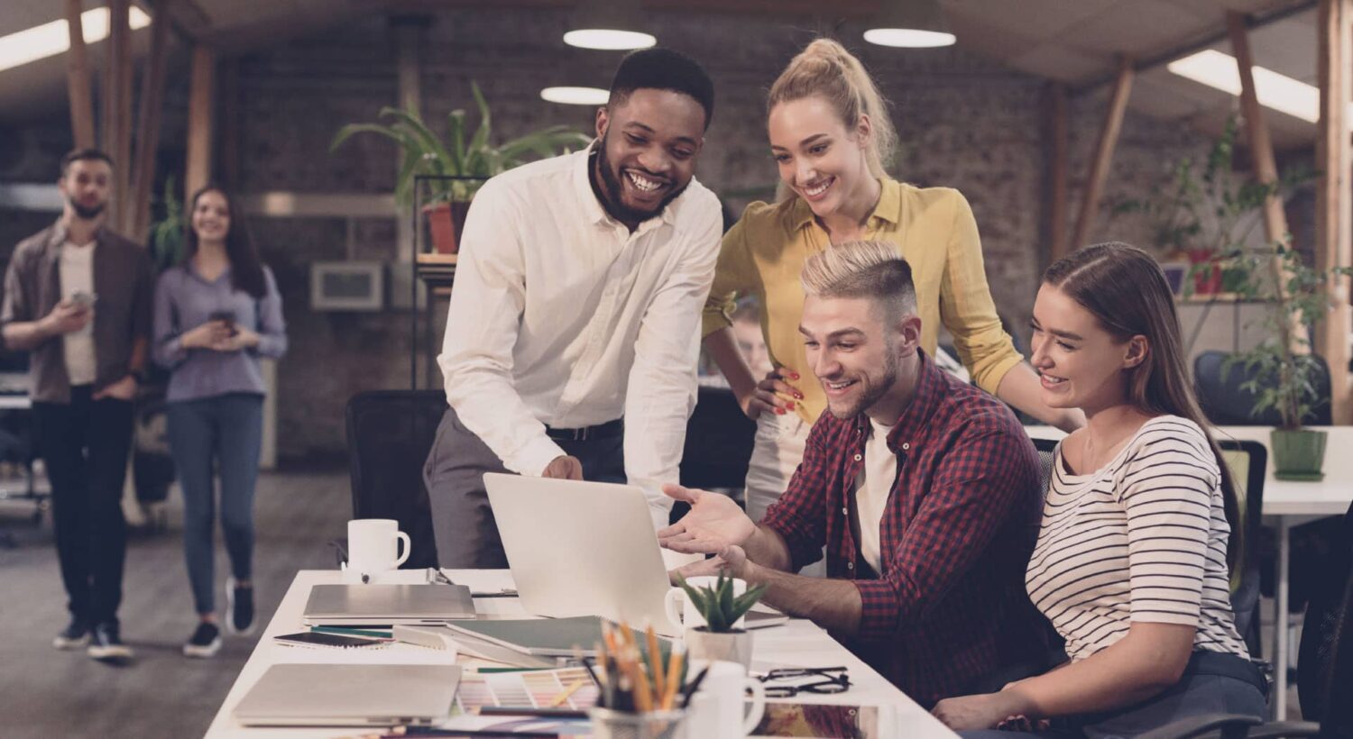 Group of professionals gathered around workstation